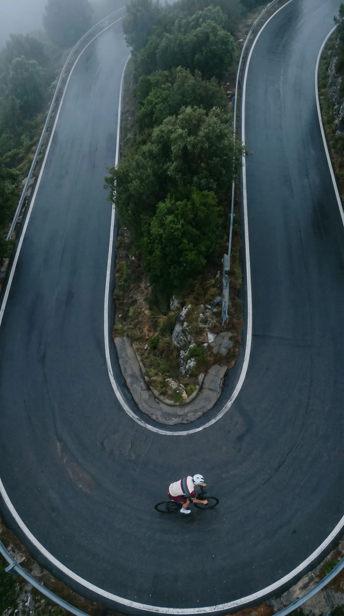 Vista cenital de una curva de herradura con un ciclista diminuto.
